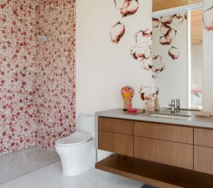 A modern bathroom featuring a wall covered in a pattern of small, colorful ceramic tiles.