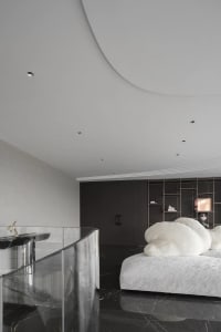 A minimalist bedroom featuring marble flooring and metallic accents