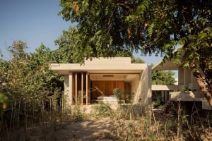 A minimalist residential space featuring a concrete exterior and open-air design.