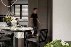 Contemporary dining room featuring marble table, glass bottles, and metal chairs.