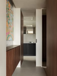 A minimalist kitchen with concrete flooring and wooden cabinets.