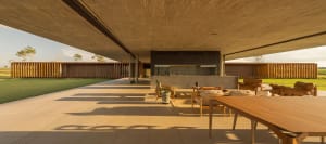 Modern patio area with wooden furniture and concrete floor, featuring a minimalist design.