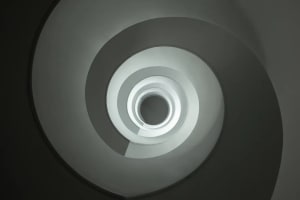 A modern staircase made of white concrete with circular steps.