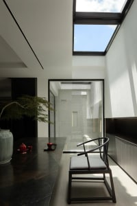 Modern living room featuring glass ceiling and minimalist furniture.