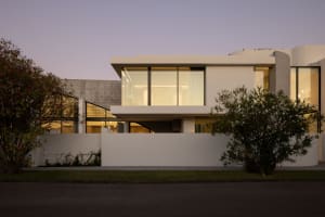 A modern residential home featuring a combination of concrete and glass materials on its exterior.