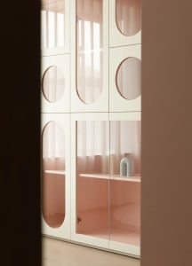 Modern storage cabinet featuring glass doors and shelves.