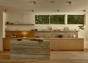 Modern kitchen featuring a stone island and wooden cabinets.
