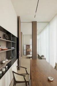 An image showcasing a minimalist living room with wooden furniture, white walls, and a large window.