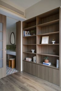 A modern living room featuring wooden shelves with books and decorations.