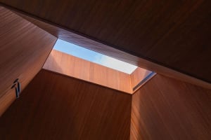 Low-angle view of a modern contemporary interior with wooden walls and a wooden skylight