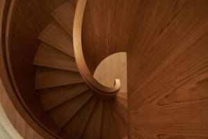 Modern, wooden, circular staircase with a spiral design.