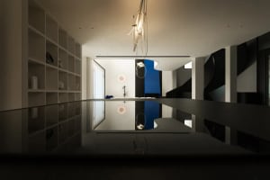 Modern interior design featuring glass, wood, and metal elements.
