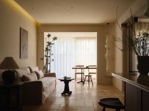 A modern living room featuring a beige leather sofa, black furniture, and plants.