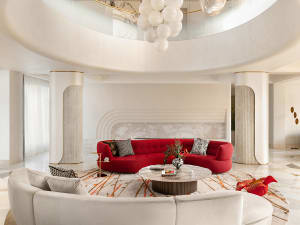 A modern living room with a red sofa on a round rug.