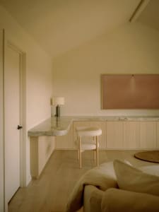 A minimalist residential interior with a marble countertop and wooden furniture.