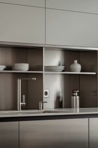 A modern residential kitchen featuring metallic surfaces and sleek design elements.