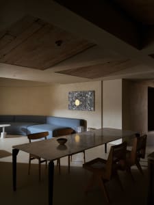 A sleek, modern dining room with a marble table and wooden chairs.