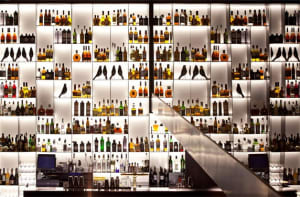 Well-stocked bar interior with bottles and glassware.