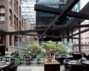 Restaurant interior featuring a modern industrial design with glass, concrete, and steel elements.