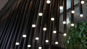 Modern industrial interior featuring exposed metal pipes and illuminated lighting fixtures.