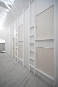 A minimalist bedroom with a concrete floor and walls.