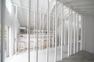 Minimalist interior design featuring a loft bar with white steel and wood finishes
