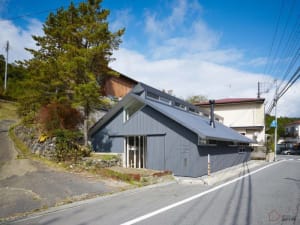 A minimalist residential building with a metal siding exterior.