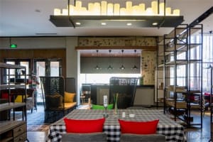 Restaurant interior with industrial design elements, featuring exposed concrete walls, metal accents, and wooden furniture.