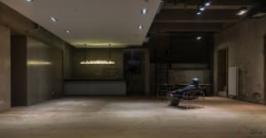 A minimalist empty loft with concrete walls and a wooden floor.
