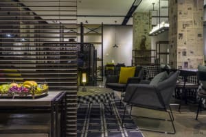 Modern interior design of a hotel reception area with metal, wood, and fabric materials.