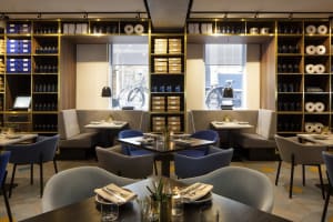 Modern restaurant interior with glass shelves, comfortable seating, and stylish decor.
