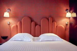 Modern bedroom with an orange upholstered headboard and white bedding.