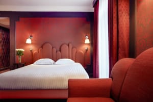 Modern bedroom with bright red fabric headboard and curtains.