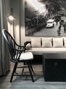 Scandinavian living room featuring a black armchair, a white sofa, and a black side table.