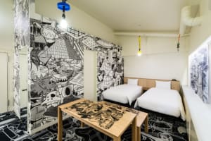Modern hotel room with twin beds and colorful, abstract mural walls