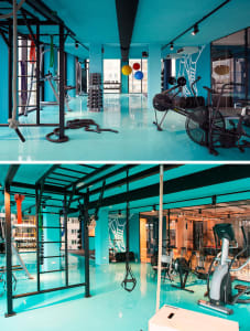 Industrial-style gym with metallic equipment, concrete flooring, and glass partitions