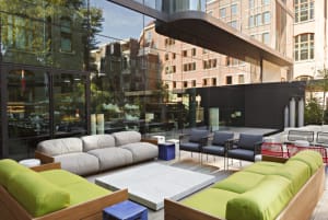 Modern outdoor lounge area with sofas, chairs, and tables.