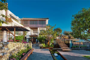 Residential building exterior featuring wood, stone, and glass materials.
