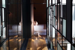 Minimalist bedroom with wooden floor and glass walls