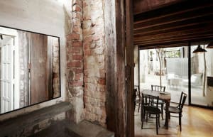 Industrial-style restaurant interior with brick walls, concrete floor, and wooden elements
