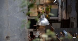 Industrial-style restaurant with metallic pendant lights hanging from ceiling.
