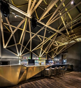 A modern bar interior featuring metal and glass materials.