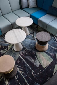 A modern seating area with flat-pack concrete furniture on a patterned rug.