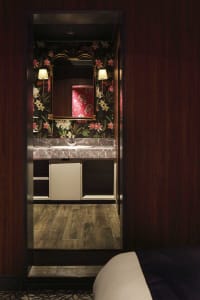 Modern bathroom with marble countertop and floral wallpaper