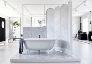 Modern bathroom featuring a white bathtub and marble tiles, showcasing contemporary design elements.