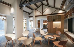 Modern cafe interior with wooden chairs, concrete flooring, and metallic accents.