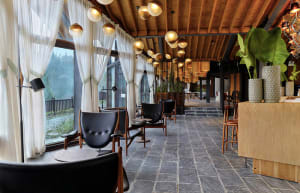 Industrial-style restaurant interior with stone flooring and leather upholstery on chairs.