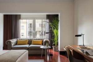 Modern industrial living room with a cozy gray sofa, accentuated by yellow throw pillows, placed against a backdrop of expans