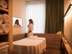 A spa room with white towels and wooden elements.