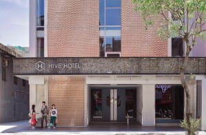 A modern hotel entrance with brick walls and glass windows.